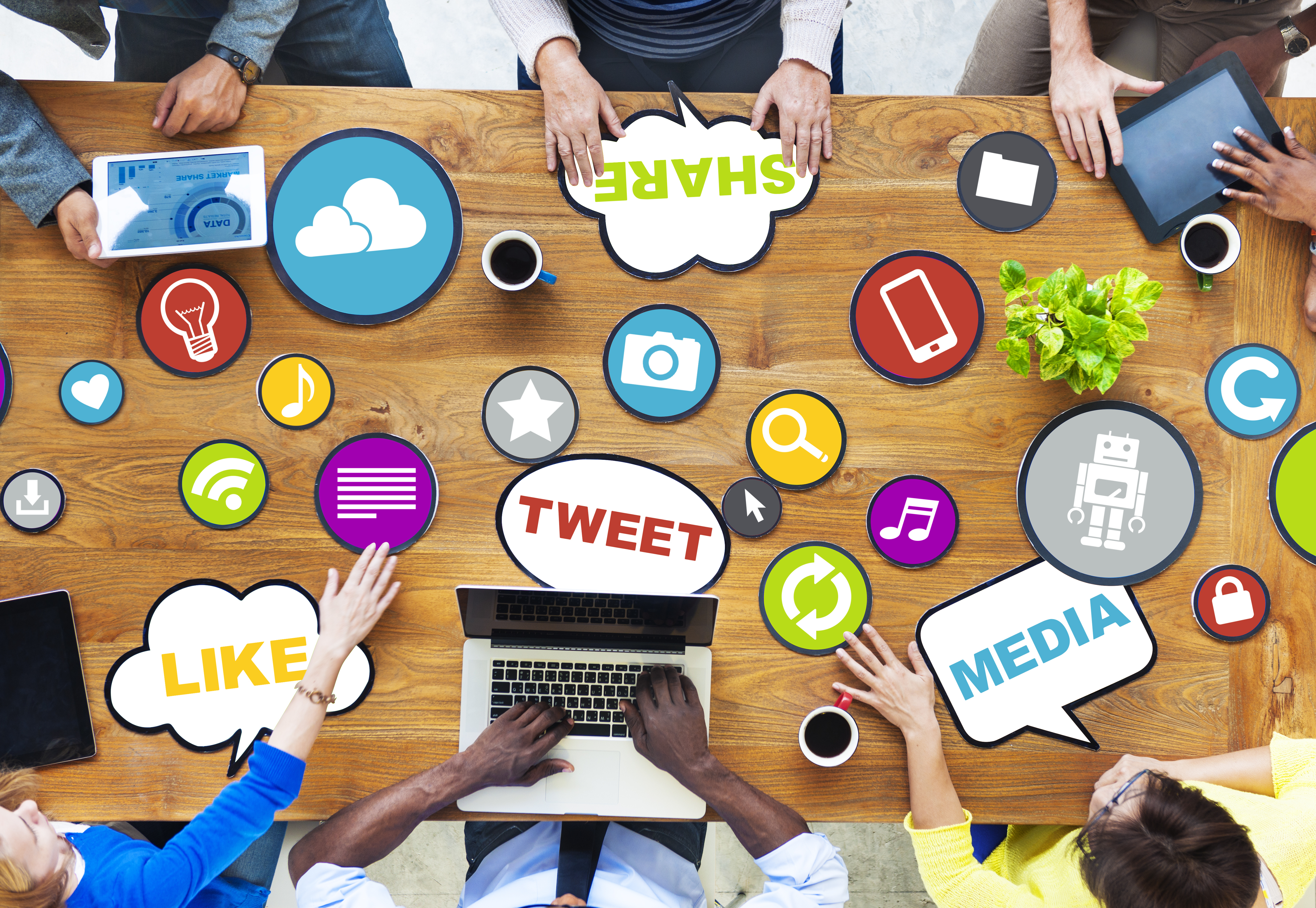 colaborative work table with various icons spread across that read 'tweet', 'share', 'like', and 'media'